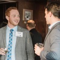 2 GVSU Alumni talk to each other while holding cups